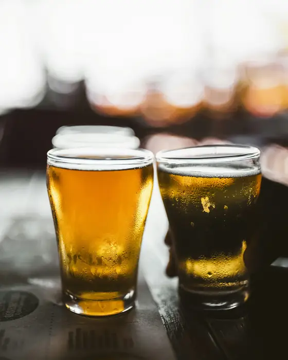 Two pints of beer on a dark table