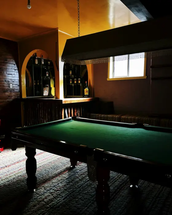 Pool table in a dark, wood-panelled bar room