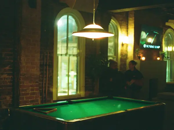 Green pool table in a dimly lit bar